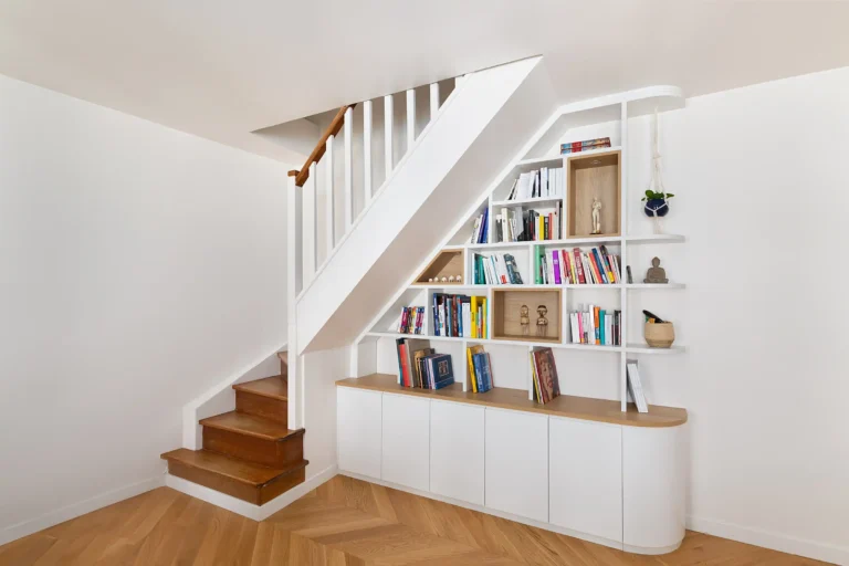 Vue d’ensemble d’une bibliothèque sous escalier design avec niches en chêne et éclairage LED