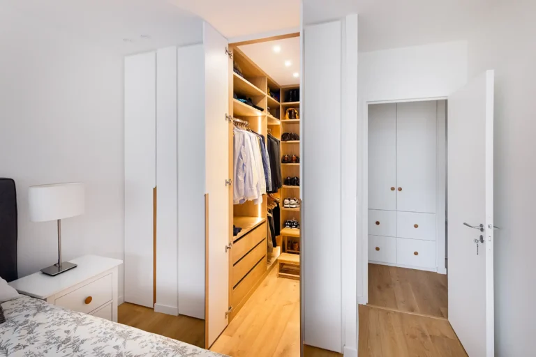 Vue d'ensemble du dressing en U avec façades blanches mates et éclairage LED intégré