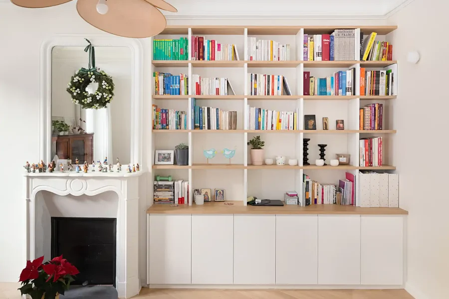 Détail d’une bibliothèque intégrée dans un appartement haussmannien avec moulures conservées