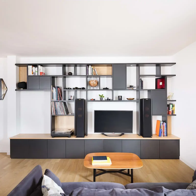 Meuble TV avec niche centrale sur mesure en bois et façades mates, intégrant une barre de son et des rangements ouverts dans un salon contemporain