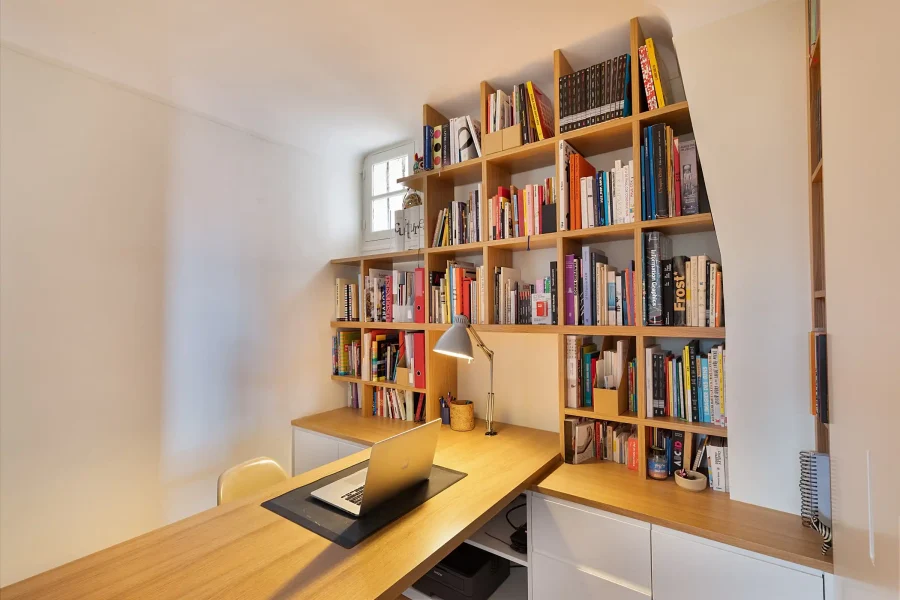 Rangement intégré sous un bureau avec séparation claustra bois pour optimiser un petit espace